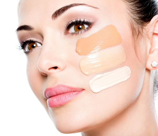 Beautiful face of  young woman with cosmetic foundation on a skin.   Beauty treatment concept
