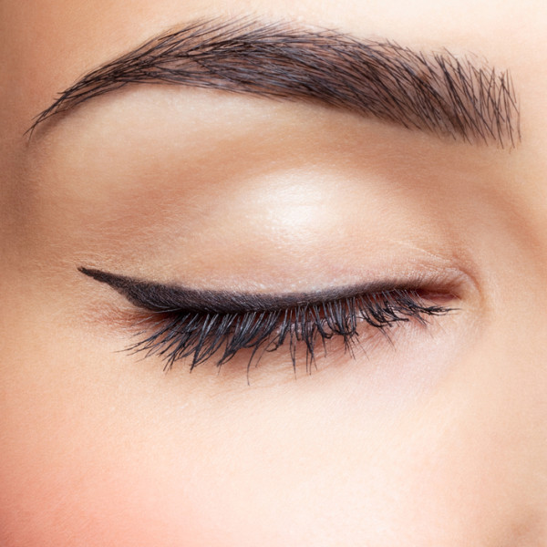 close-up portrait of young beautiful woman's closed, eye zone make up with black arrow