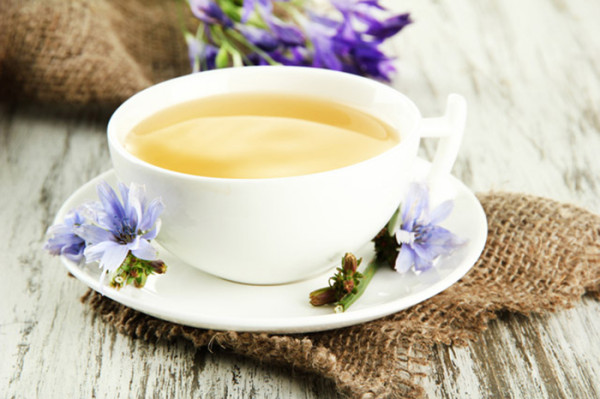Cup of tea with chicory, on wooden background