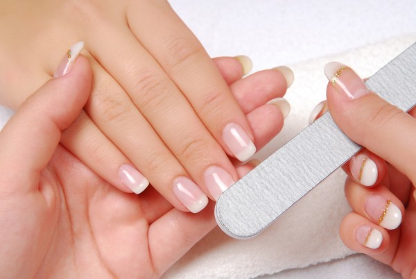 Studio nail  beautician polishing female nails