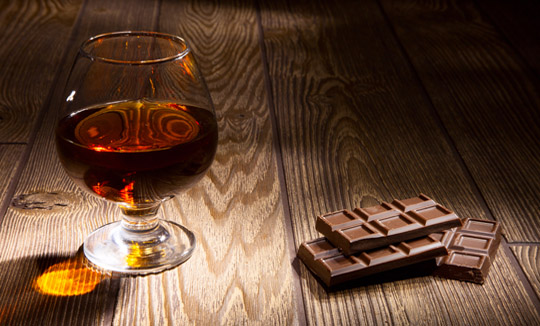 Чаша ракия с шоколад на дървена маса
