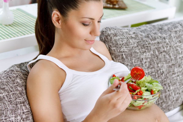 Beautiful healthy pregnant woman  eating vegetable salad