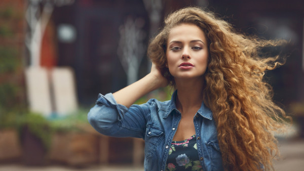 Beautiful young caucasian girl with curly hair outdoors