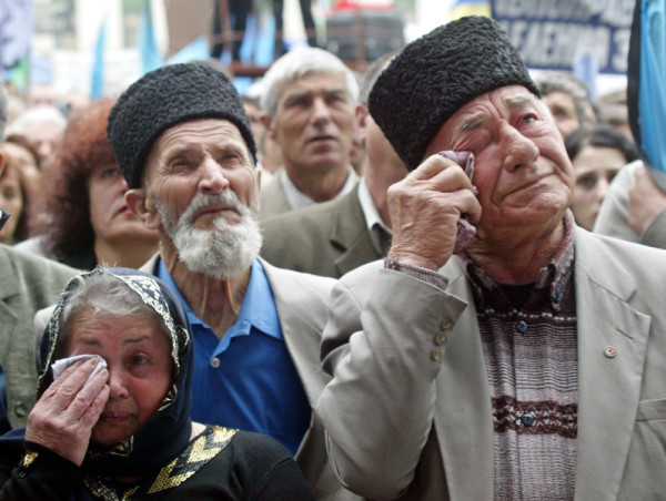 Crimean Tatars wipe their tears at a mourning rally during the 60th anniversary of deportation of ethnic Tatars under Soviet dictator Josef Stalin, in the Crimean capital of Simferopol, Ukraine, Tuesday, May 18, 2004. Thousands of people gathered in Simferopol main square to honor the memory of victims of the Soviet regime (AP Photo/Efrem Lukatsky)