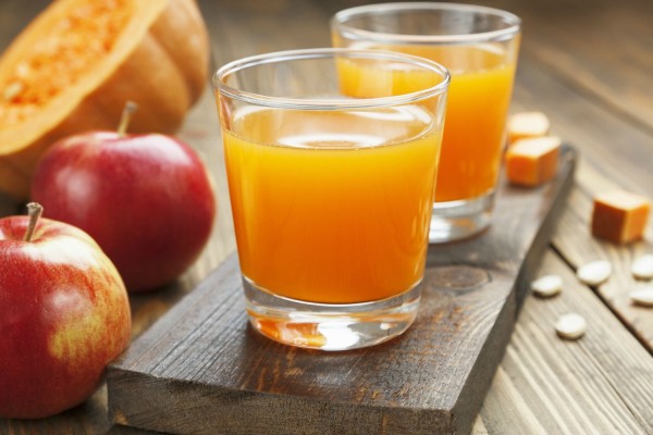 Сок од јаболка и тикви во чашите на масата