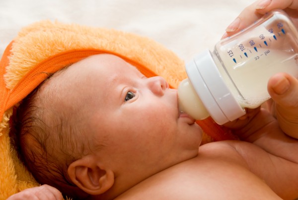 Mother give drink her baby boy by feeding bottle