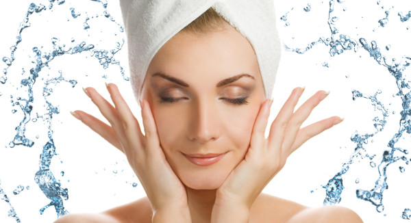 Beautiful young woman washing her face