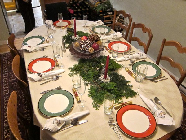 мебели-уреди-минималистичен-дизайн-на-Коледа-вечеря-маса-декорация-идеи-показва-червена-свещ-с-държач-и-коледа-топка-върху-сив-метал-държач-плюс-зелен-бор- листа-на-овална-маса-с