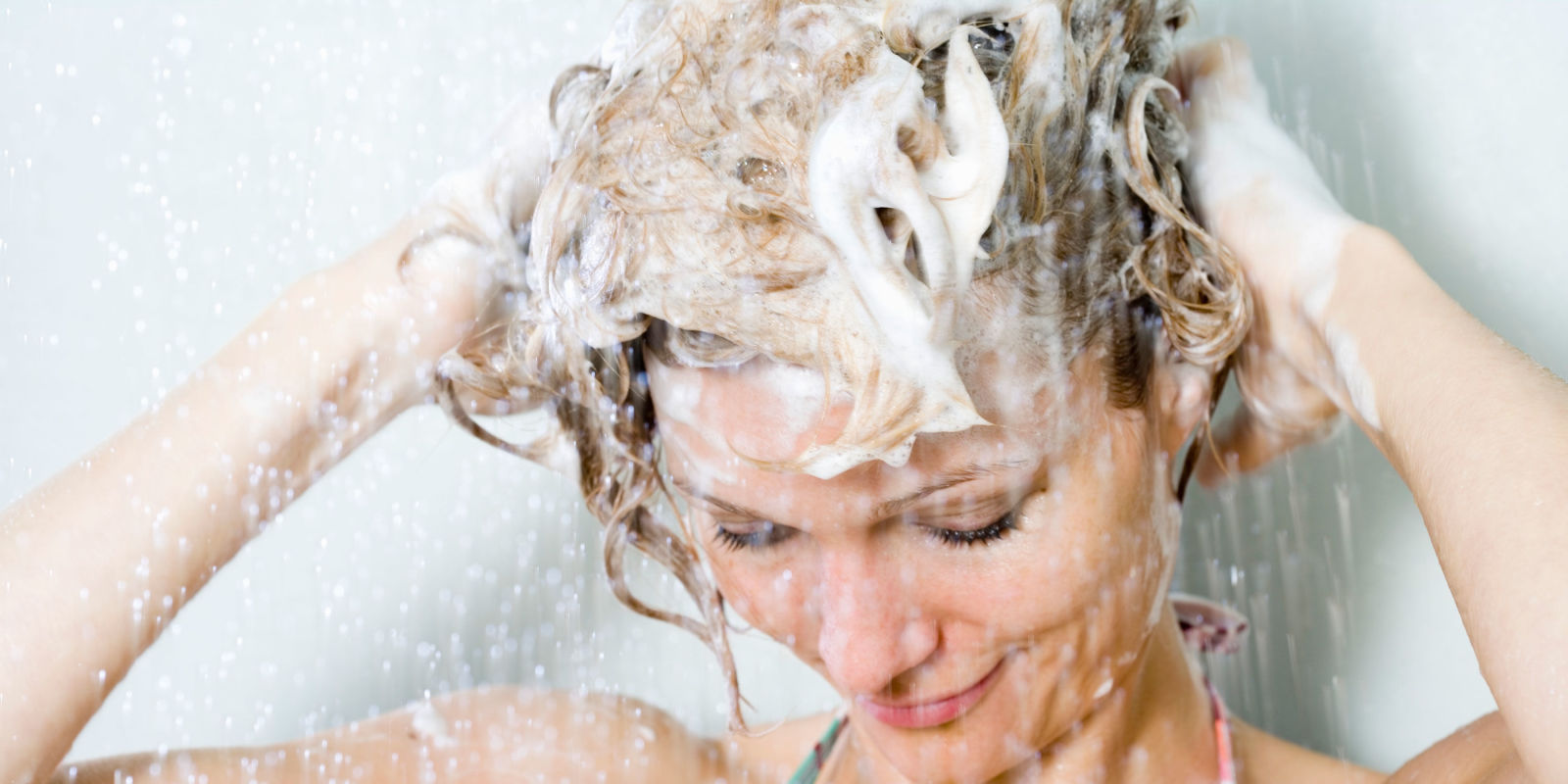 Можно мыть голову холодной водой. Мытье волос. Мыло для волос. Намыленные волосы. Блондинка моет волосы.
