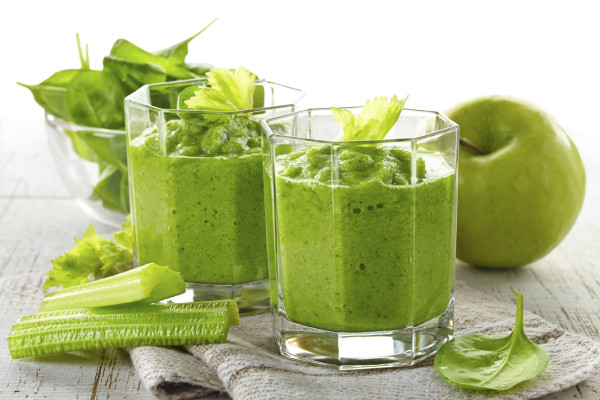 glass of green smoothie on wooden table